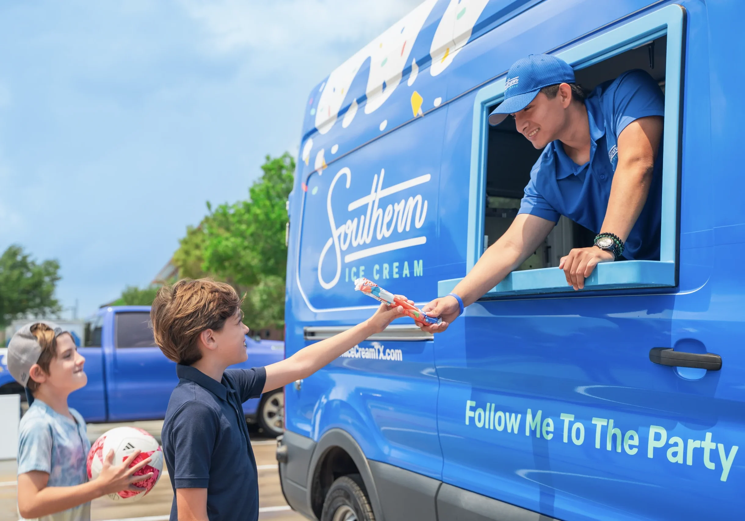 ice cream parties ice cream truck party rentals attendant smiling and handing popsicle to boys
